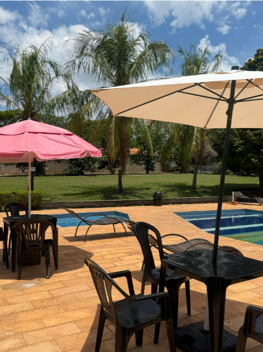Mesas e ombrelones na área da piscina